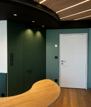 Aménagement d’un espace d’accueil professionnel avec peinture verte et éléments en bois.