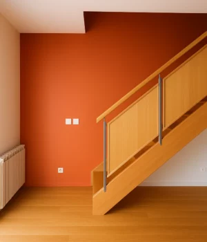 Mur peint en orange chaleureux dans un espace avec escalier en bois rénové à Lyon.