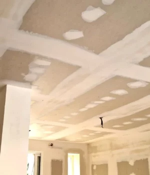 Plafond en plaques de plâtre avec bandes et enduits en cours de finition.