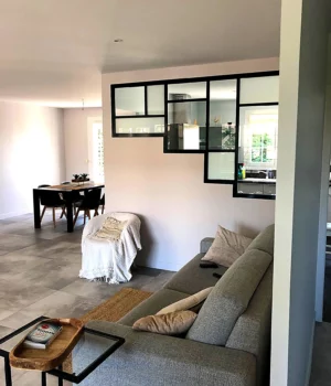 Salon rénové avec verrière intérieure noire et espaces ouverts
