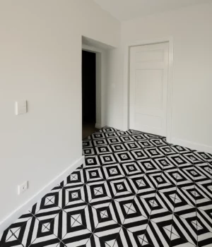Sol en carreaux noirs et blancs à motifs géométriques dans un appartement rénové.